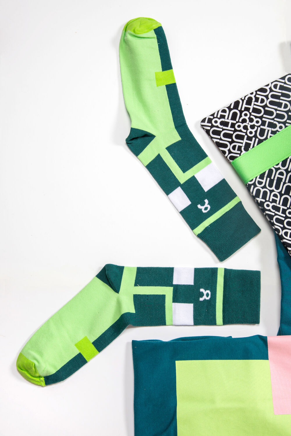 Des chaussettes de marque, un accessoire imprimé et un t-shirt plié disposés ensemble, représentant une petite collection conservée en stock d'entrepôt