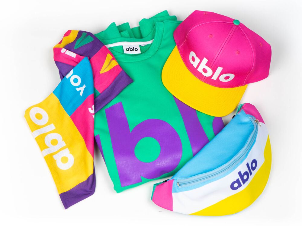 A vibrant fully custom apparel collection in a company's own colours, including a sweater, cap and bag designed end to end as the brand