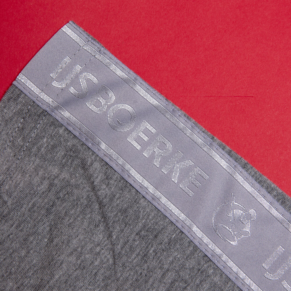Primer plano de un cinturón de prenda de marca con una banda de logo jacquard plateada tejida, producida según una especificación fija