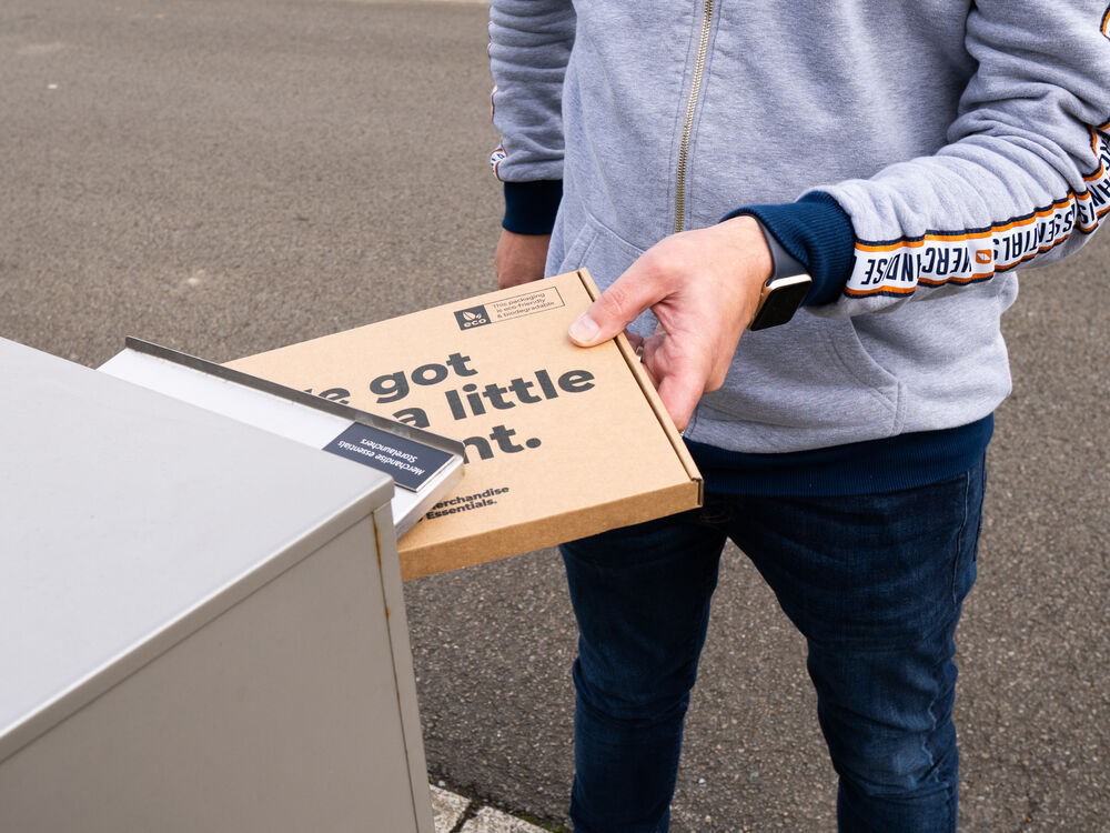 A recipient collecting a branded gift box with a personal message printed on the lid, showing the final step of a personalised corporate gifting programme