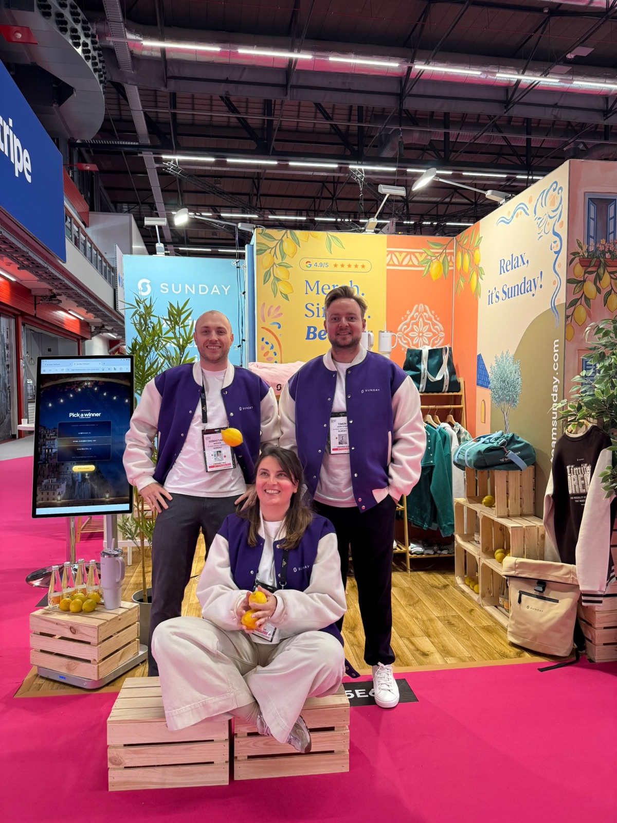 The Sunday team at the Money20/20 booth in front of the Merch. Simply. Better. backdrop