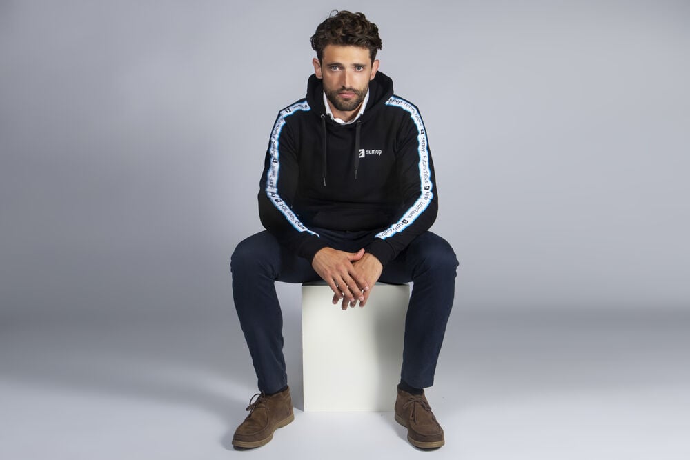 Corporate clothing example: a hoodie with contrast sleeve tape and an understated logo, decoration that fits the brand identity