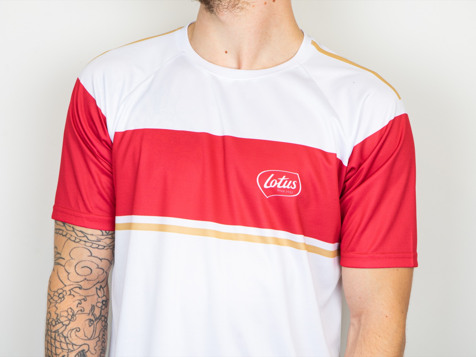 A Lotus-branded custom sports jersey in bold brand colours, an example of a company kit design that uses the full surface