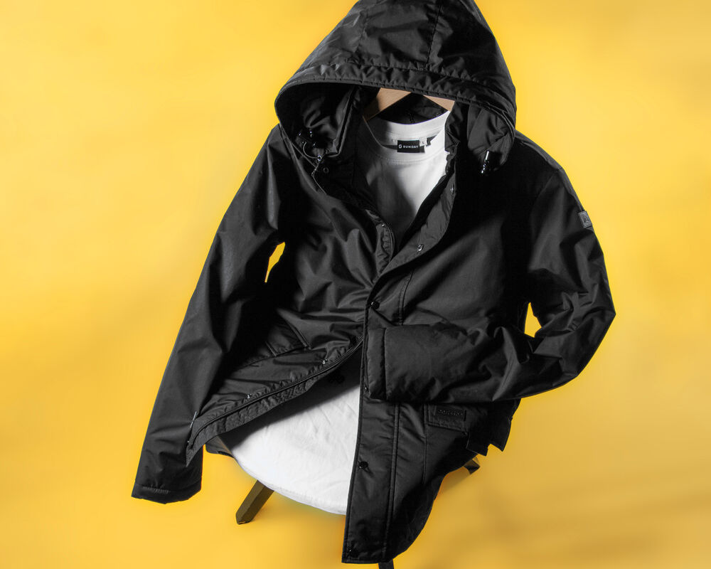 A design-led branded jacket photographed against a bold yellow backdrop, an example of a corporate gift built around a concept instead of a catalogue default