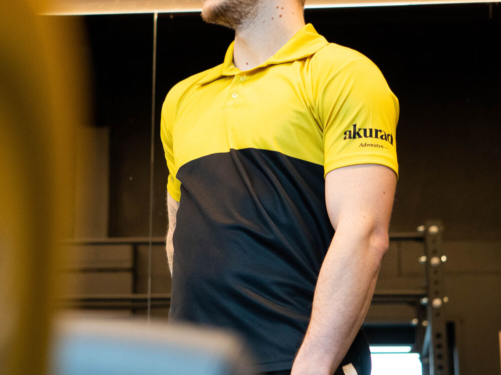 Een technicus in een gepersonaliseerde tweekleurige bedrijfspolo aan het werk