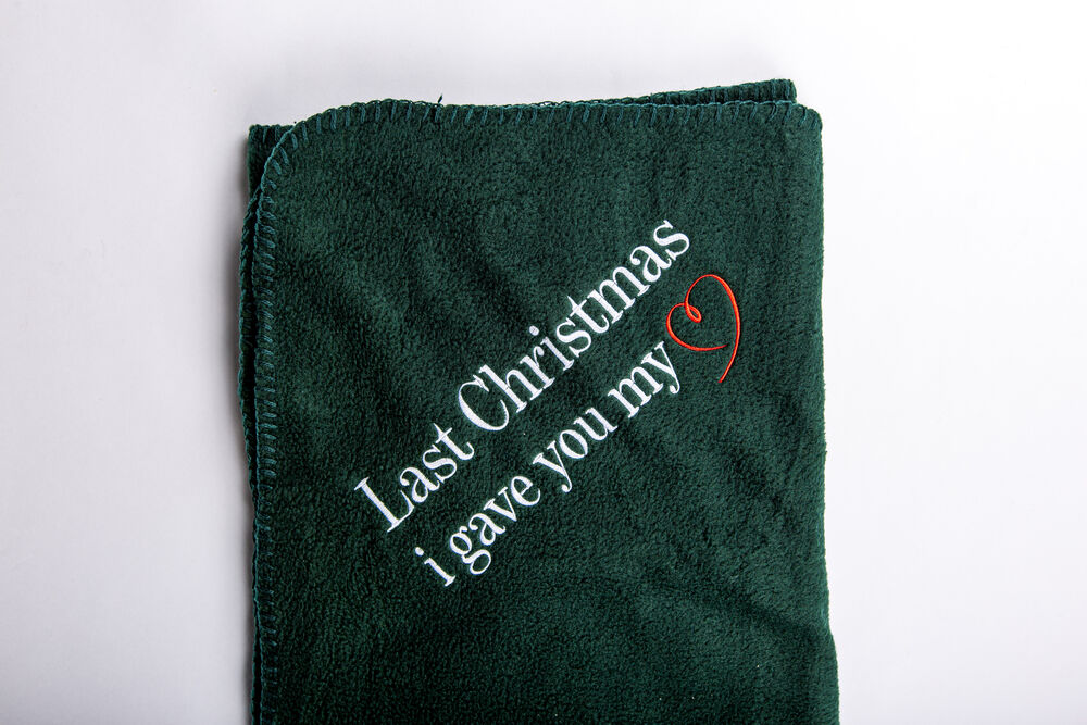 A branded blanket presented as a corporate Christmas gift, cozy company gift in festive setting