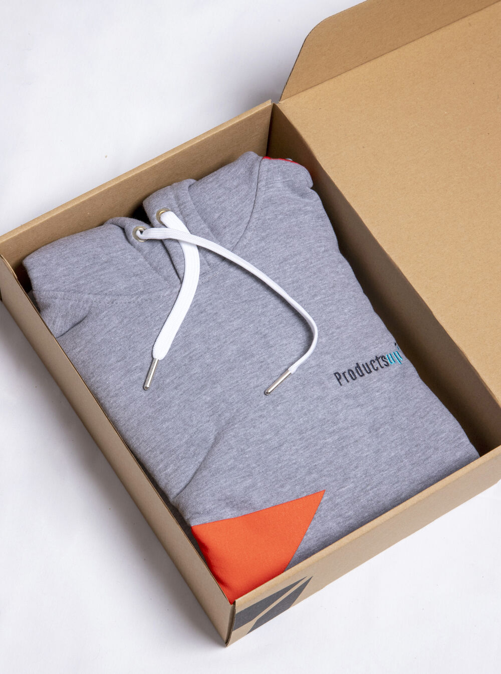 A branded hoodie packed flat inside a printed kraft gift box, showing the picking and packing step that an automated corporate gifting program takes over