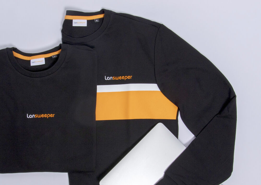 A black branded sweatshirt and matching t-shirt with orange and white blocking, a coherent collection built for an ongoing programme