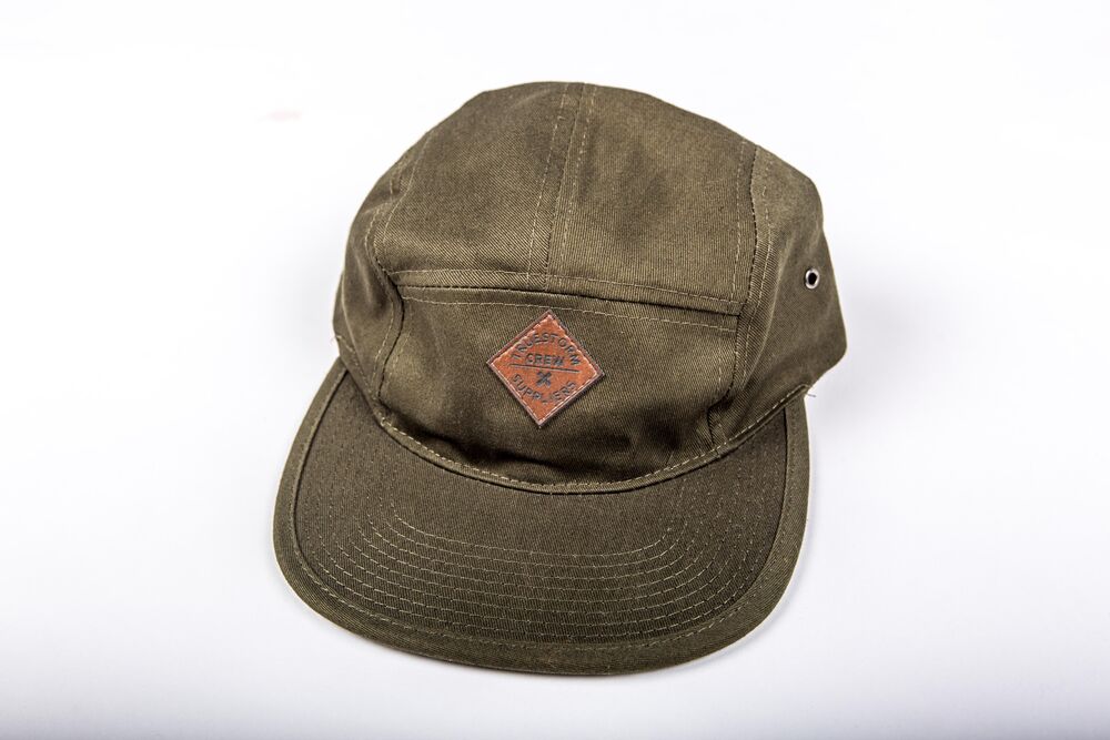 An embroidered leather patch on a garment, a premium sewn-on decoration for a custom polo