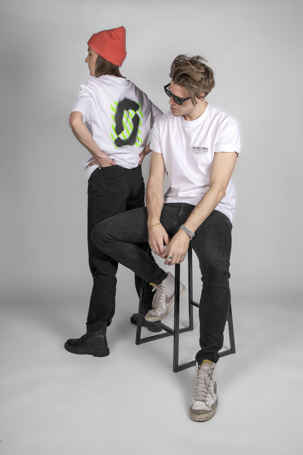 Zwei Personen in individuell bedruckten Marken-T-Shirts in einem Studio, ein Beispiel für die Bekleidungskompetenz, die einen Markenmerchandise-Spezialisten von einem Katalog-Wiederverkäufer unterscheidet