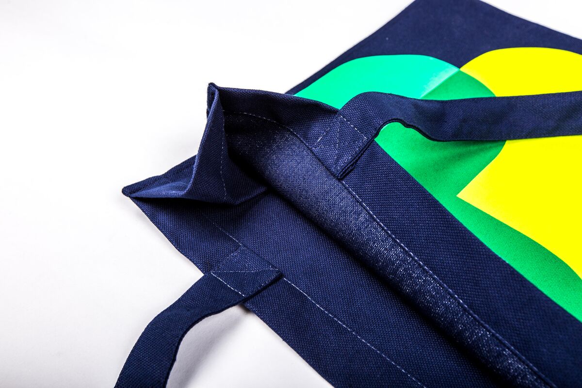 A navy printed cotton tote bag photographed close up, the classic corporate promotional gift used for broad distribution and brand awareness