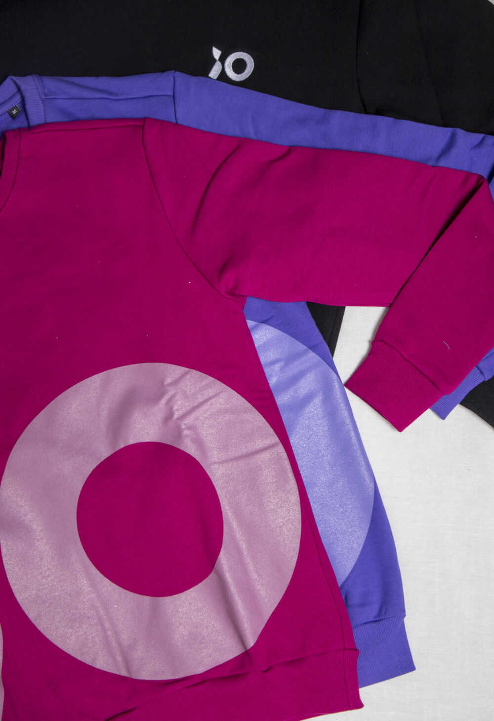 Gama de ropa laboral de marca una junto a otra, con logo bordado y estampado en los colores de la marca