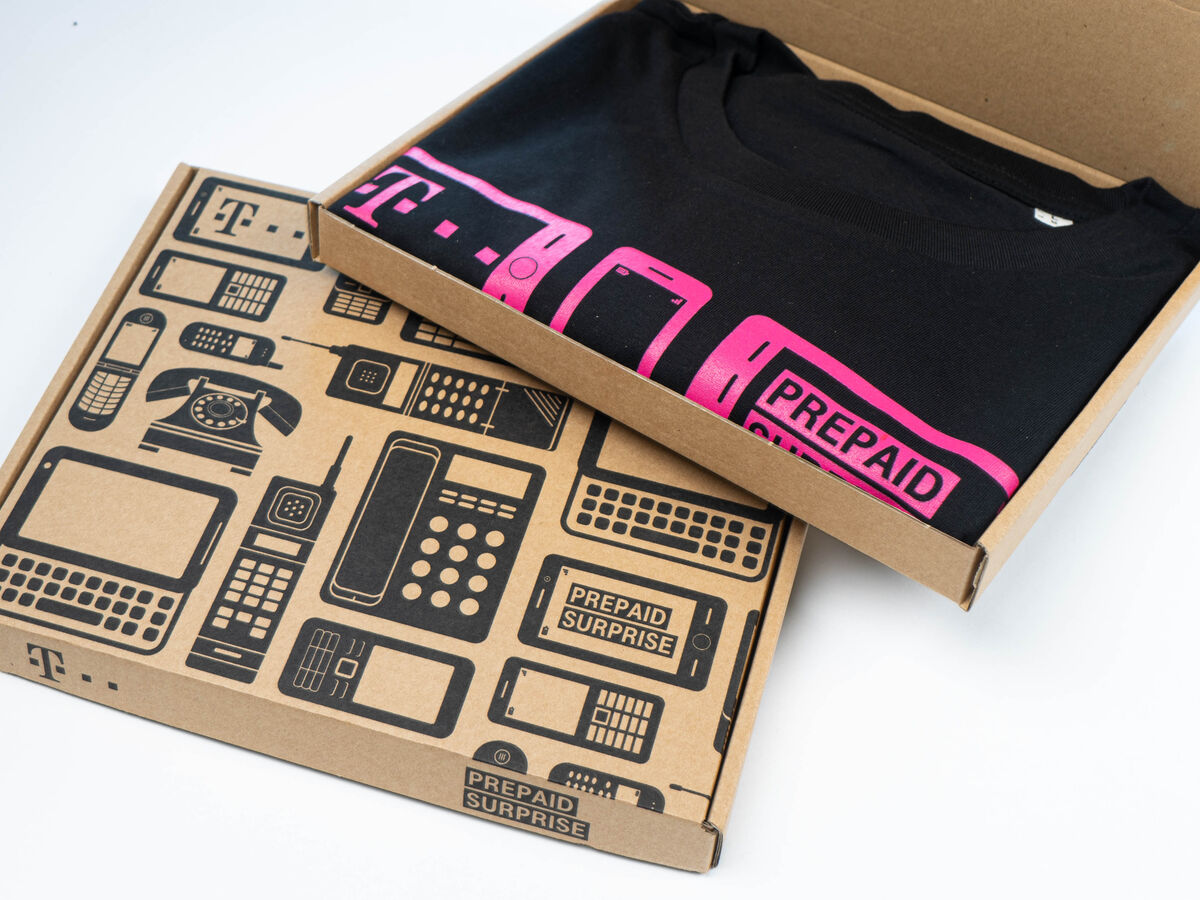A branded corporate gift: a company logo tee presented inside a printed, decorated gift box, an existing product turned into a gift with tasteful branding