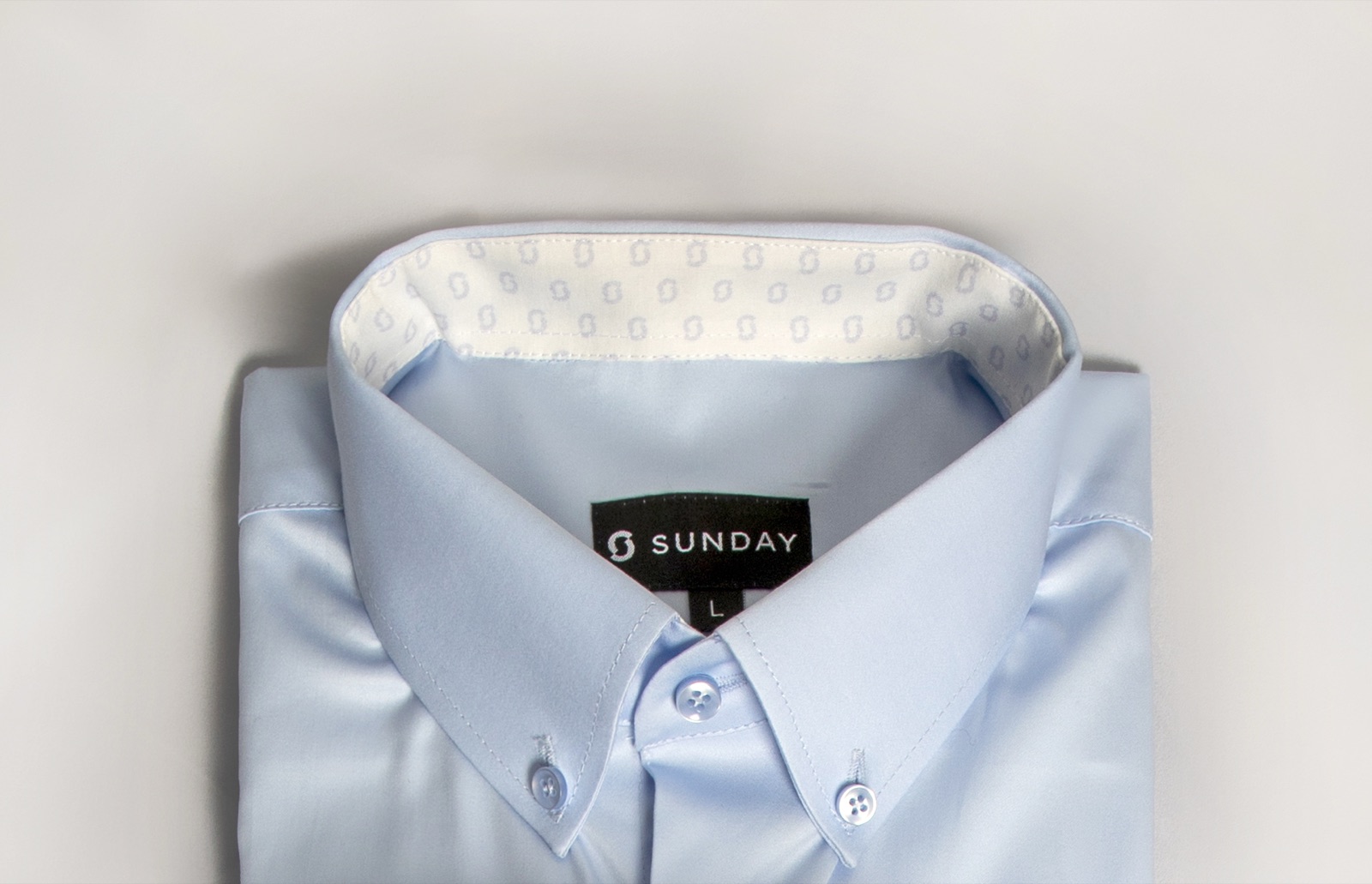 Close detail of a Sunday-branded business shirt, the kind of quality that lowers cost-per-wear