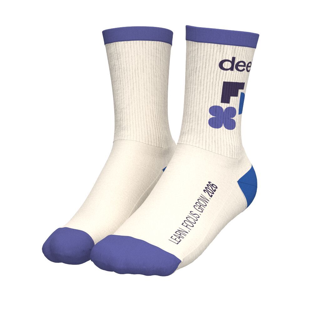A pair of cream custom socks with a blue heel, toe and cuff and a small logo on the shaft, an example of subtly branded merch that pairs well with an edible gift