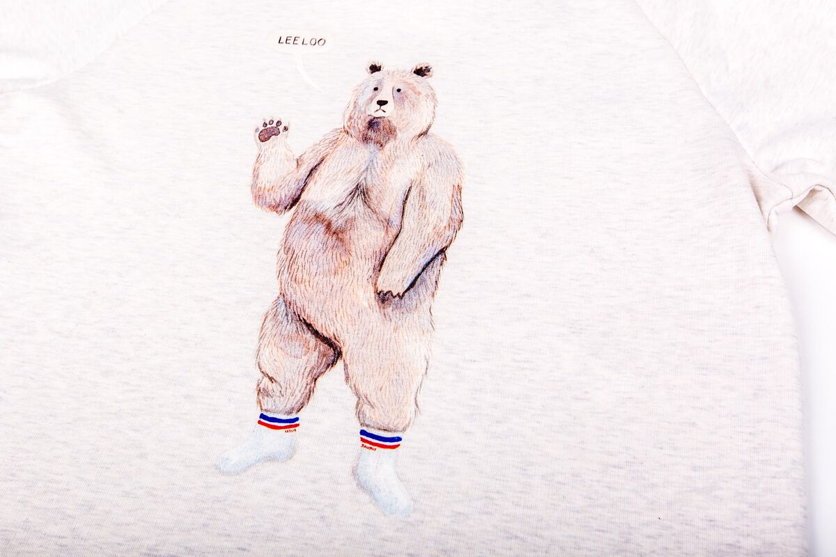 Een crèmekleurige sweater met een gedetailleerde bedrukte illustratie, het soort opvallend eenmalig stuk dat goed werkt in een vooraf samengestelde swagbox
