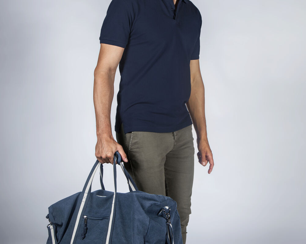 A branded weekend bag carried by hand, showing how travel bags work as unique corporate gifts that stay in use long after the campaign